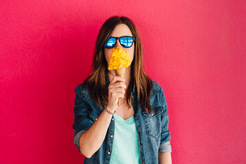 Hipster girl eats popular Italian Gelato ice cream in the background of a pink wall