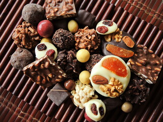 Assortment of fine chocolates in white, dark and milk chocolate on wooden background