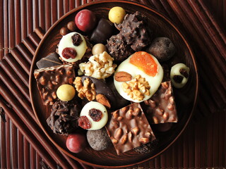 Assortment of fine chocolates in white, dark and milk chocolate on wooden background