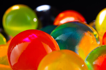 multi-colored silicone gel balls in a glass on a black background