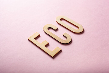 eco word text wooden letters on pink background