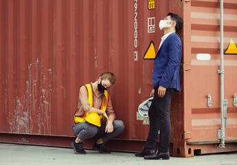 Young worker and engineer sitting failed and stressed at cargo container