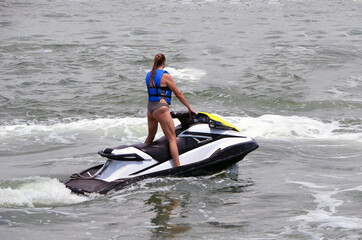 Young tall and slender woman jet skier