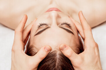 Close up top view of relaxed woman receiving head massage in spa wellness center.