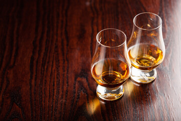 glass of whisky spirit brandy on dark brown background