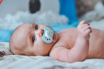 portrait of a little boy. cute baby. three month old boy smiling. baby with a pacifier