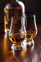 Bottle and glass of whisky spirit brandy on dark brown background