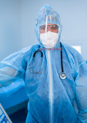 Doctor wearing protection Suit for Fighting Covid-19,Corona virus with surgery room background.