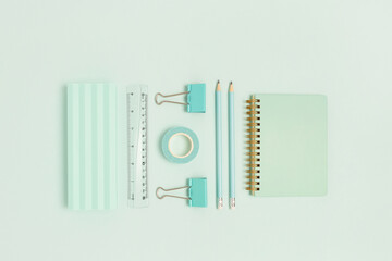 Set of office supplies on a mint pastel background. Monochrome creative concept.
