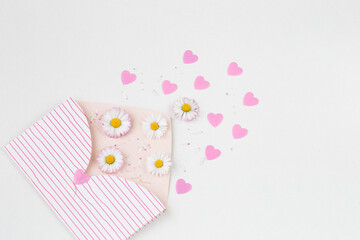 daisies, pink hearts and petals fly out of the envelope