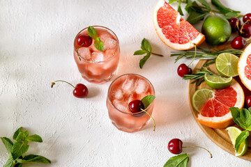 Mocktail with pink syrup and sweetened cherry