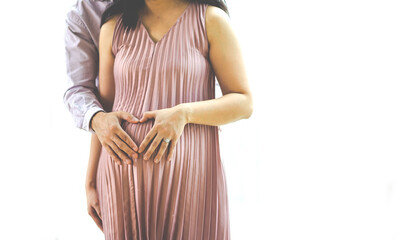 Portrait Happy Pregnant woman in dress holds hands and making heart with her hands on big belly. Love happy family concept. Pregnancy and parenthood concept. Copy space for text.