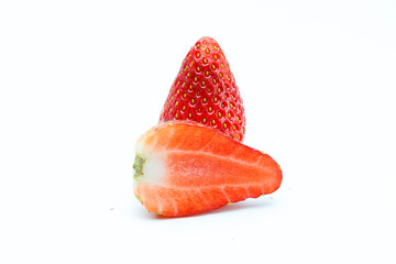 Fresh strawberries and strawberry slices on a white background.