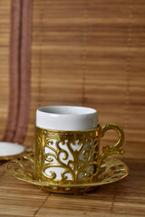 gold cup for coffee on a light background