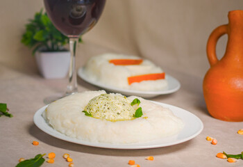 Georgian traditional food and cuisine ghomi with cheese and red wine.