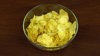 Hands of people take chips from a large plate. The company of friends eats potato chips. Hands close up