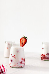 Milkshake with fresh summer strawberries, glass jars with strawberry milkshake, delicious healthy breakfast
