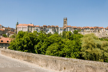 Obraz premium Fribourg, Freiburg, Kathedrale, St. Nikolaus, Altstadt, Altstadthäuser, historische Häuser, Stadtmauer, Stadt, Stadtspaziergang, Sarine, Fluss, Steinbrücke, St. Johannbrücke, Brücke, Sommer, Schweiz