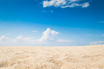 View of empty tropical sand beach with puffy white cloud and blue sky background