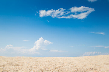 View of empty tropical sand beach with puffy white cloud and blue sky background