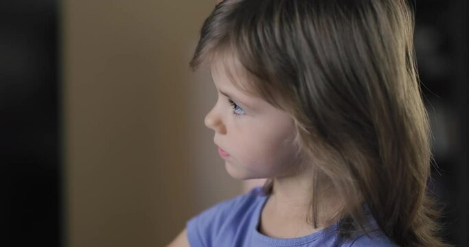 Adorable little girl sitting and playing with a pencil