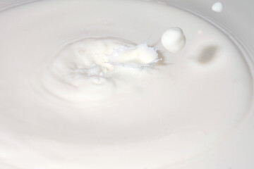 Drops of liquid milk pouring down or white drops with ripples