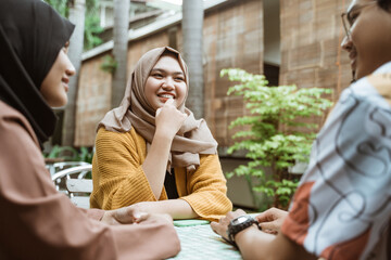 veiled female students smile while chatting with group members