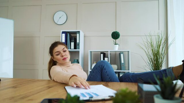 Bored office girl procrastinating at work place