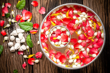 Roses, jasmine and marigolds In a large silver bowl on a wooden floor , Songkran Festival or Thai New Year