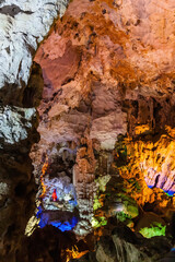 Naklejka premium Stalactite and stalagmite formations in a limestone cave of Halong Bay, Vietnam