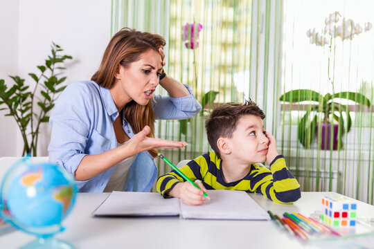 Mother Becoming Frustrated With Son Whilst Doing Homework. Mom makes the best teacher ever. Mother scolds a child for poor schooling and homework at home
