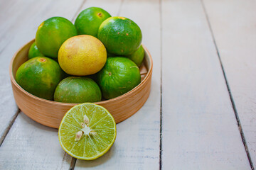 Lemon in basket on white wood.