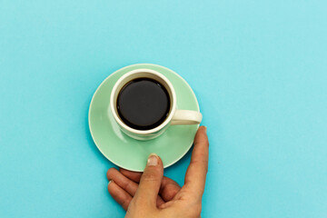 hand holding cup coffee isolated on blue background
