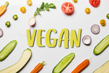 top view of fresh sliced vegetables on white background with vegan illustration