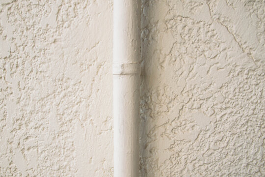 white water pipe in a white wall of small textures 