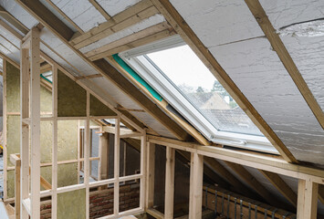 Loft conversion, unfinished project, silver insulation, roof windows, wood structure of the walls, selective focus
