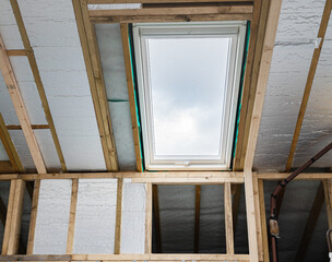 Loft conversion, unfinished project, silver insulation, roof windows, wood structure of the walls, selective focus