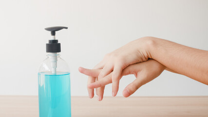 Asian woman using alcohol gel hand sanitizer wash hand for protect coronavirus. Female push alcohol bottle to clean hand for hygiene when social distancing stay at home and self quarantine time.