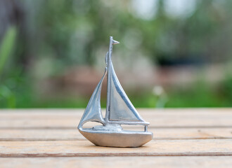 Metal sailboat in the garden on a table
