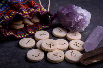 Obraz na płótnie Canvas Wooden runes on a black background. Ancient alphabet known as the futhark are divided into the three aetts