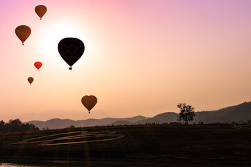 Hot air balloon above the mountains in the sunset sky. Balloon silhouettes above the mountains while the sunsets.
