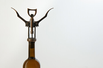 Glass wine bottle and corkscrew on a white background top view.