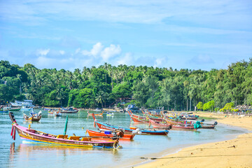 Fototapeta na wymiar Peaceful background of nature landscape and local lifestyle of Thai fisherman village and wooden boats floating with sea view in Phuket, Thailand. Thailand tourism background