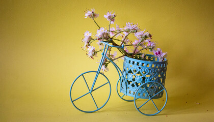 Vintage bicycle with a basket of flowers on a yellow background