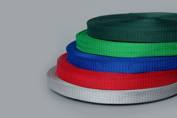 rolls of textile tape on gray background. color tape production.