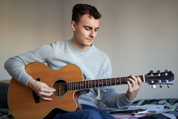 Obraz premium Teenage boy playing guitar