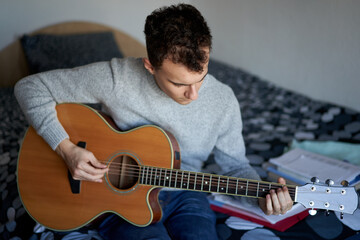 Obraz premium Teenage boy playing guitar