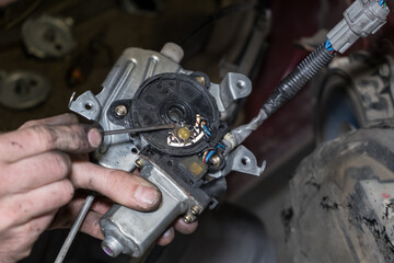 Fototapeta na wymiar Close up view of male hands check car window lifter motor mechanism with screwdriver. Car repair concept.