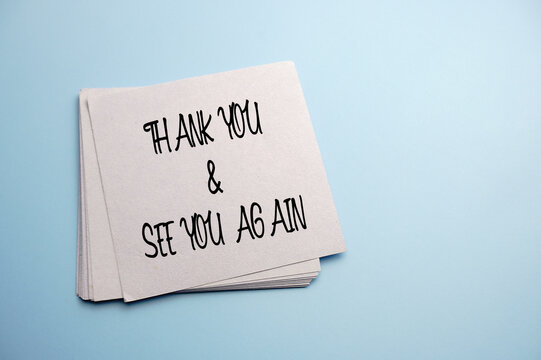 note paper written thank you and see you again over blue background