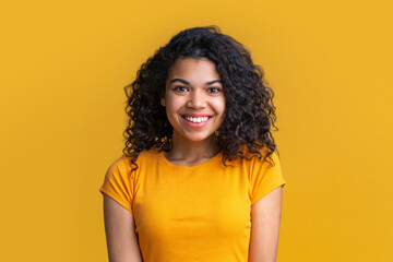 Studio shot of cute african american girl on bright yellow background